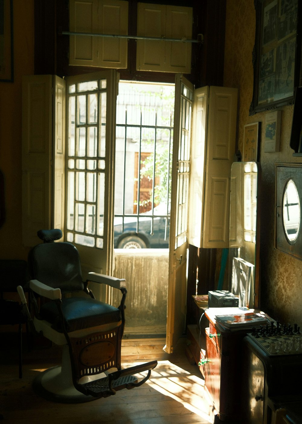 The shop door propped open onto the street, sunlight across the floor
